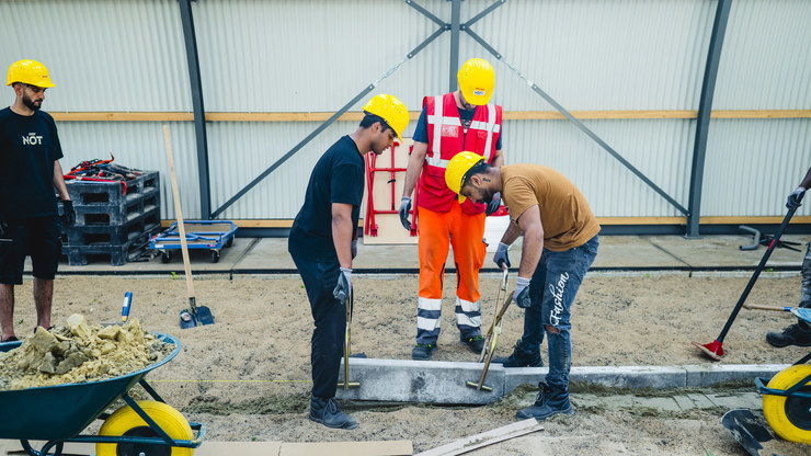 Deelnemers doedagen aan het werk als wegenwerker