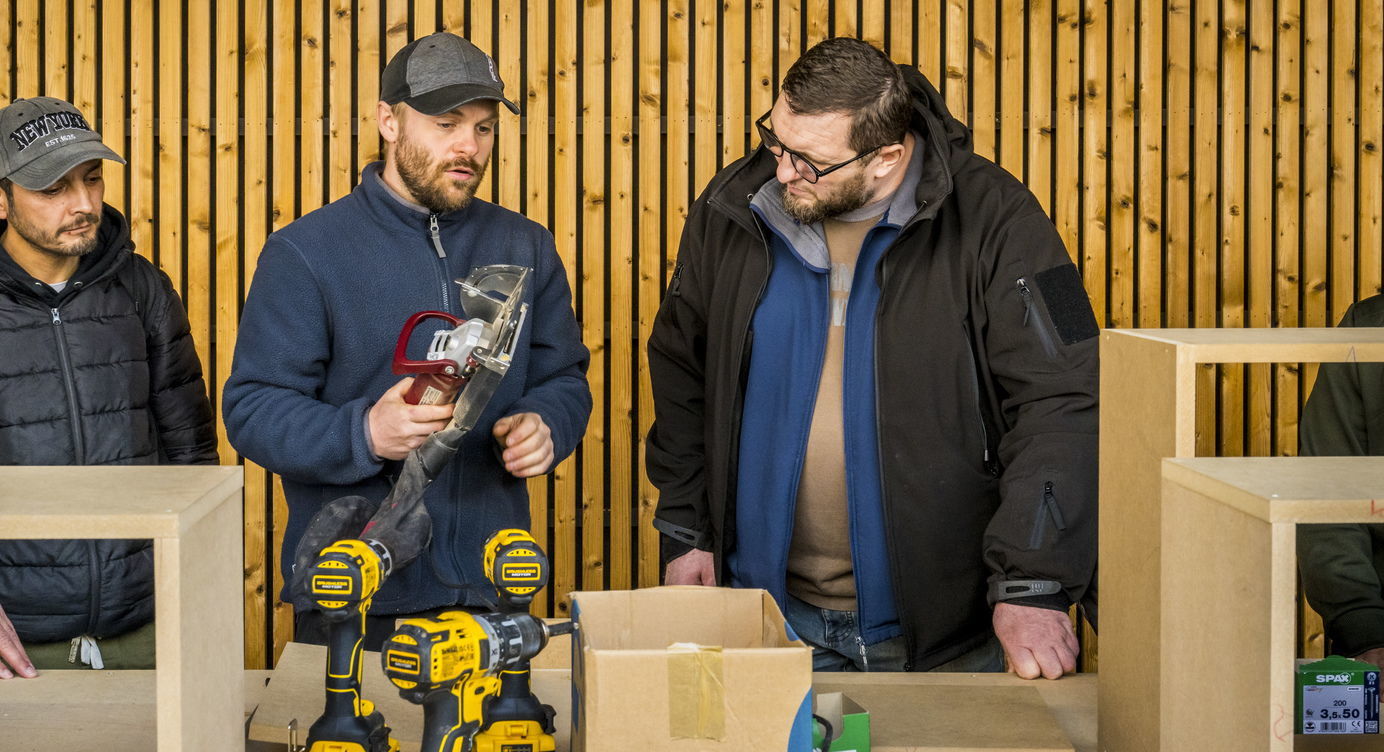 Deelnemers aan de Bouw Wow krijgen uitleg over houtbewerking