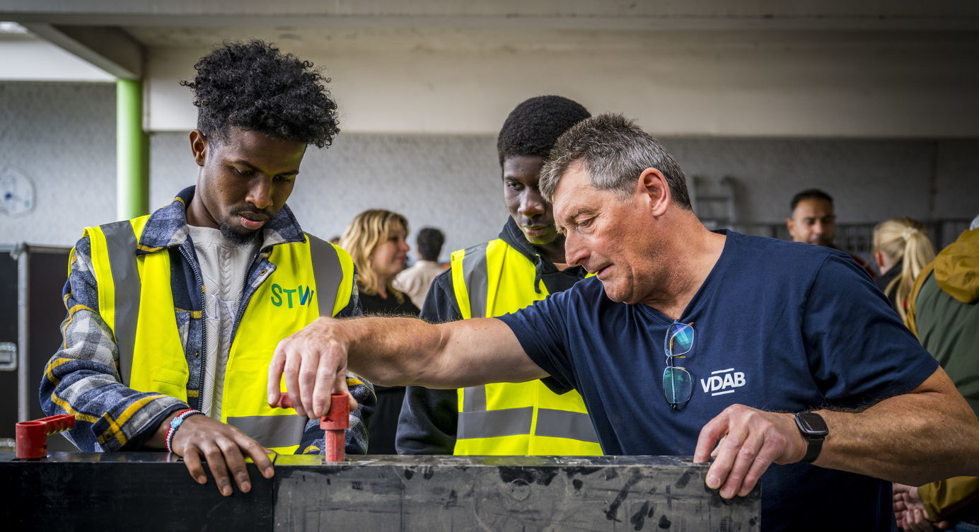 Deelnemers op de Bouw Wow bij Ligo krijgen een korte opleiding als bekister